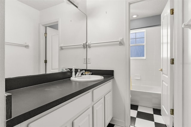 bathroom with tiled shower / bath combo and vanity