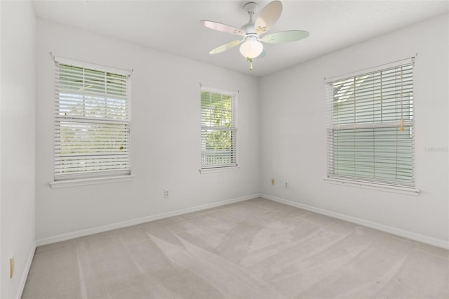 carpeted spare room with ceiling fan