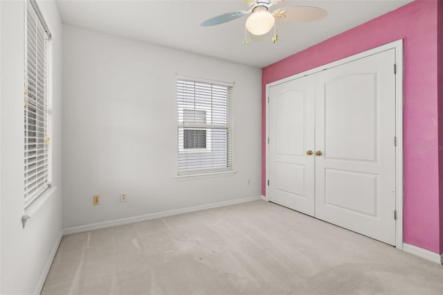 unfurnished bedroom featuring light colored carpet, ceiling fan, and a closet