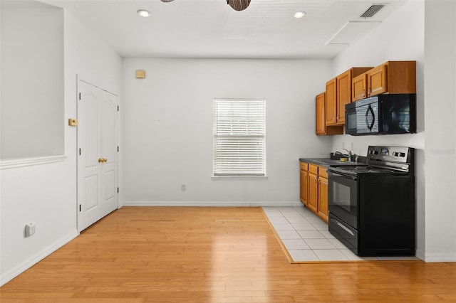 kitchen with sink, light wood-type flooring, and black appliances