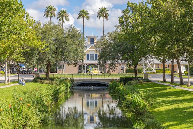 view of property's community with a water view and a yard