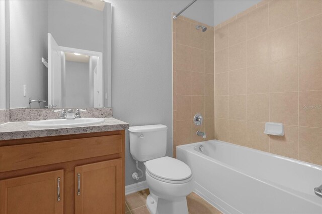 full bathroom with vanity, tiled shower / bath combo, tile patterned floors, and toilet