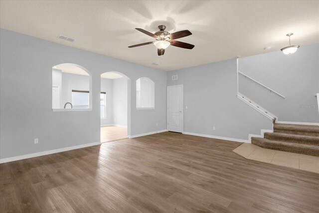 unfurnished living room with wood-type flooring and ceiling fan