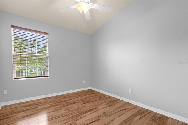 unfurnished room with lofted ceiling, light hardwood / wood-style floors, and ceiling fan