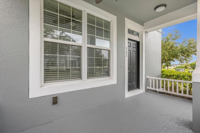 property entrance featuring ceiling fan and a porch