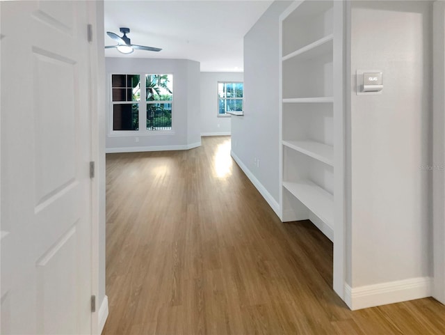 hall featuring built in features and light wood-type flooring