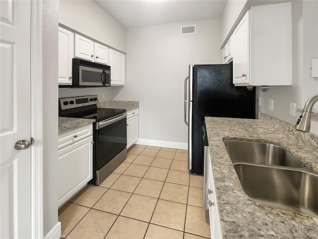 kitchen featuring sink, white cabinetry, light tile patterned floors, light stone countertops, and stainless steel appliances