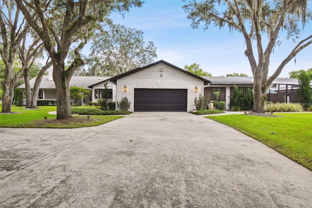 ranch-style house with a garage and a front lawn