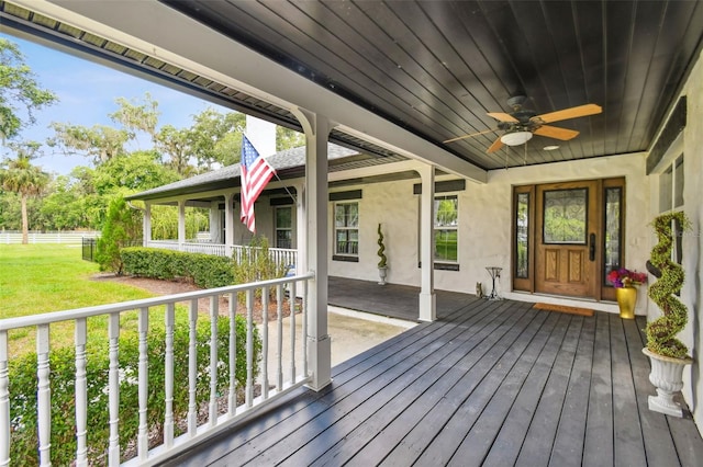 deck with ceiling fan, a yard, and covered porch