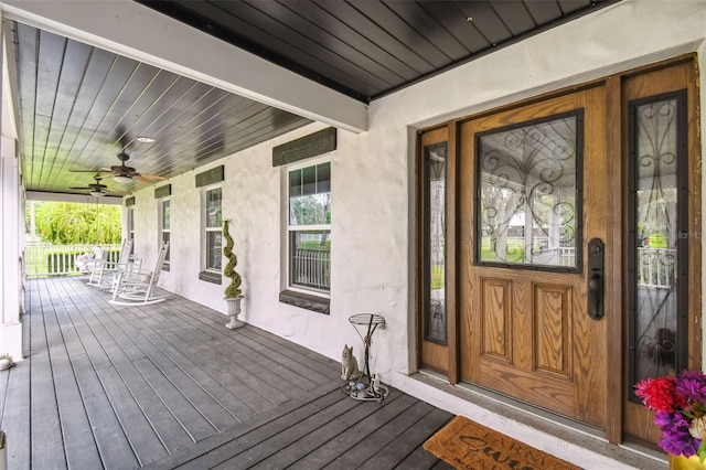 doorway to property featuring ceiling fan and a porch