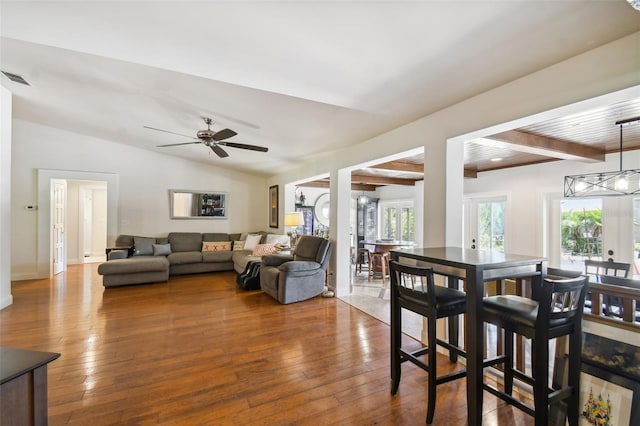 living room featuring hardwood / wood-style flooring, wood ceiling, ceiling fan, and vaulted ceiling with beams