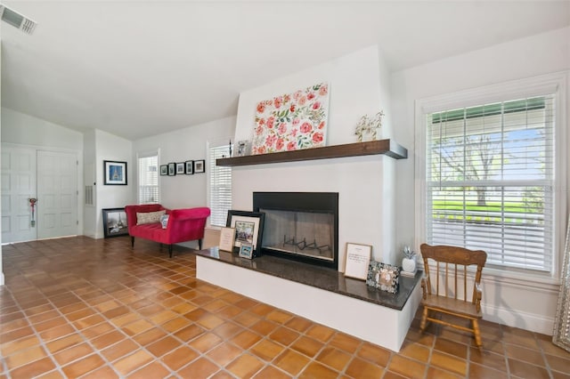 living room with vaulted ceiling, a wealth of natural light, and tile patterned flooring