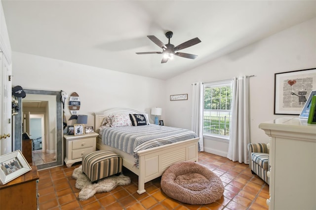 tiled bedroom with ceiling fan and vaulted ceiling