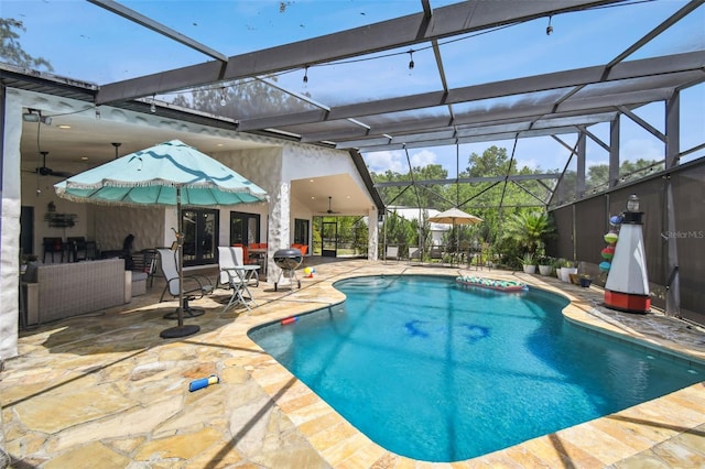 view of swimming pool featuring ceiling fan, glass enclosure, and a patio