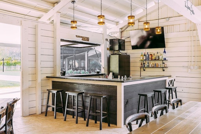 bar with beam ceiling, wooden walls, and pendant lighting