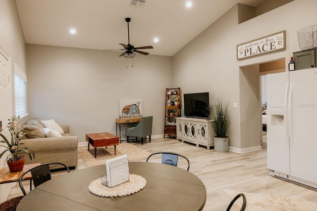 living room featuring ceiling fan, light wood-type flooring, and high vaulted ceiling