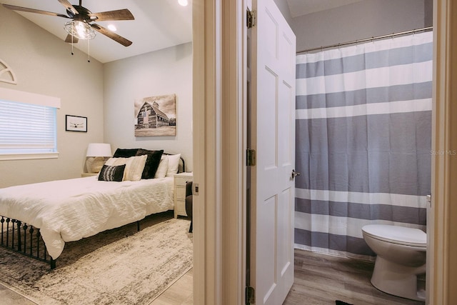 bedroom with ceiling fan, vaulted ceiling, and light wood-type flooring