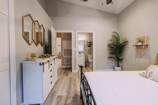 bedroom featuring ensuite bath, ceiling fan, vaulted ceiling, and light hardwood / wood-style flooring