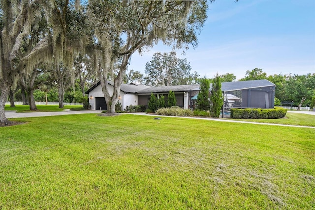 view of front of property with a lanai, a front lawn, and a garage