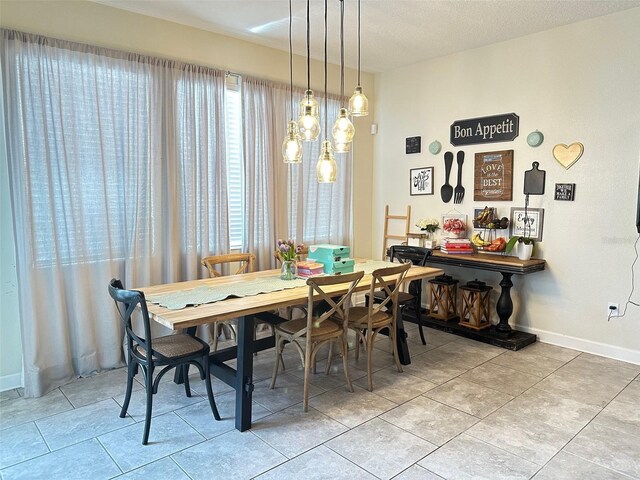 dining room featuring tile patterned flooring and a textured ceiling