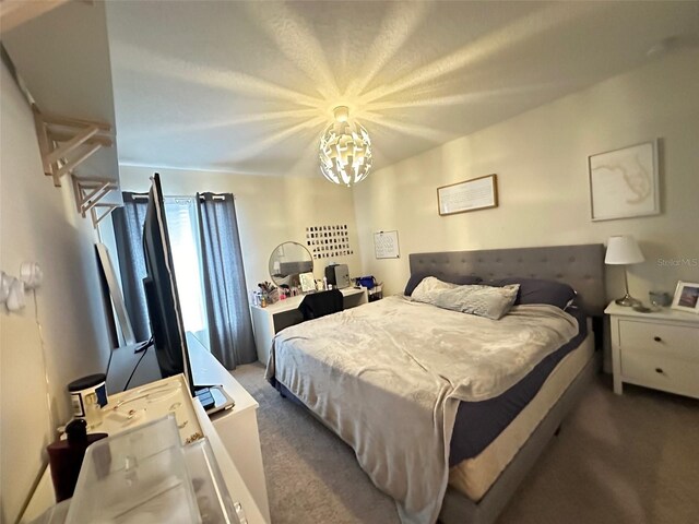 carpeted bedroom with a notable chandelier