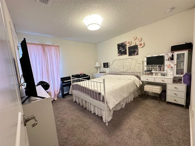 bedroom featuring a textured ceiling and carpet flooring