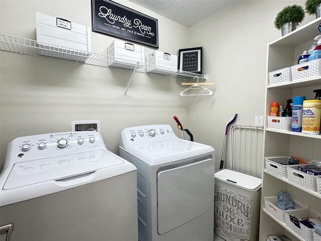 clothes washing area featuring washer and clothes dryer and a textured ceiling