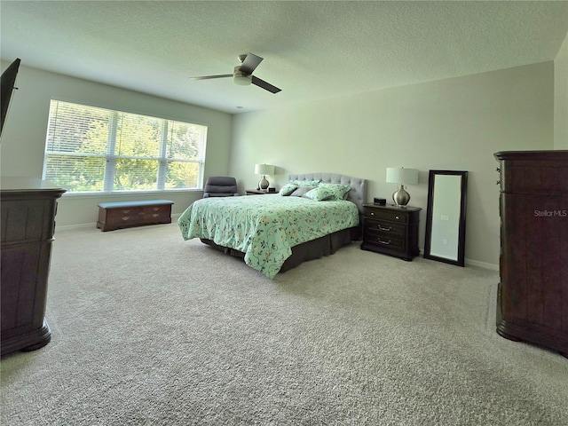 carpeted bedroom featuring a textured ceiling and ceiling fan