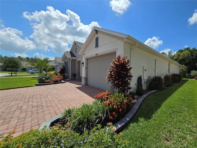 view of side of home with a garage and a lawn