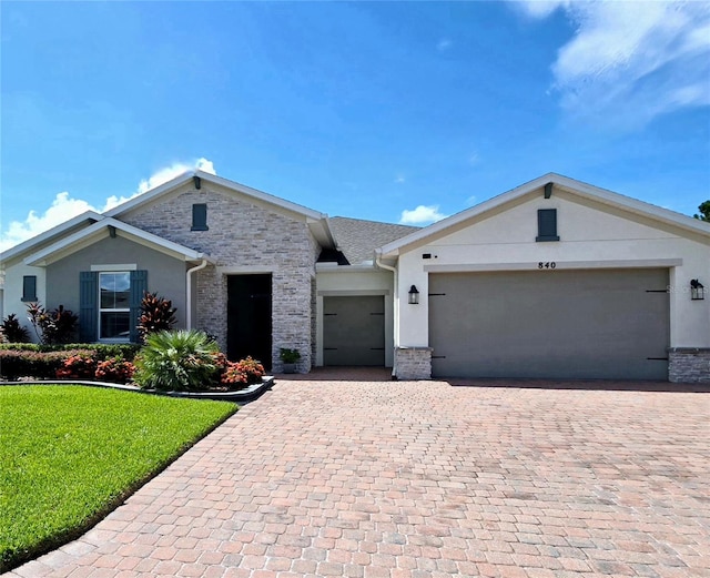 ranch-style house featuring a front lawn and a garage