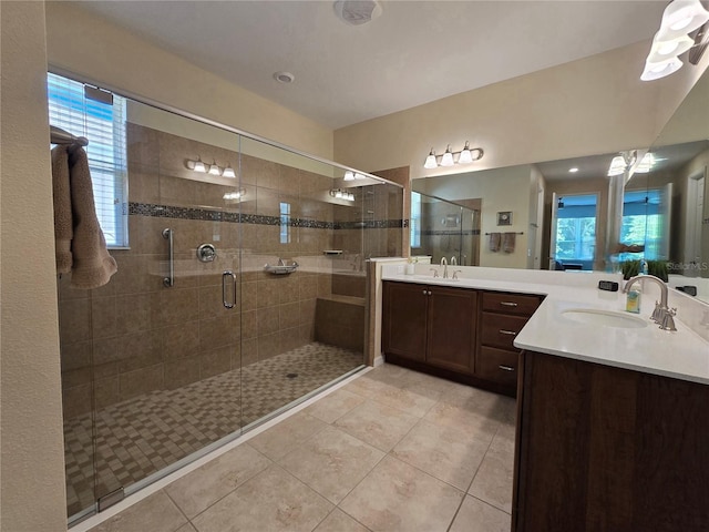 bathroom featuring tile patterned flooring, vanity, and walk in shower