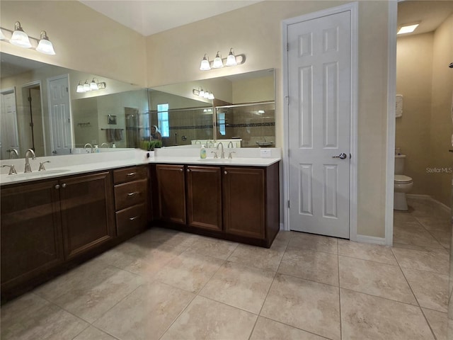 bathroom featuring tile patterned floors, toilet, a shower with shower door, and vanity