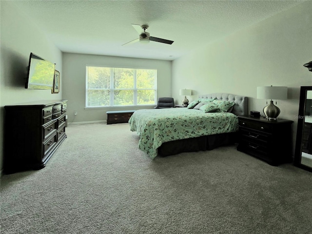 carpeted bedroom featuring ceiling fan and a textured ceiling