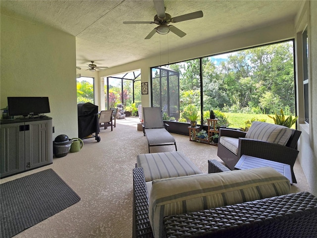 view of patio with ceiling fan, an outdoor hangout area, and glass enclosure