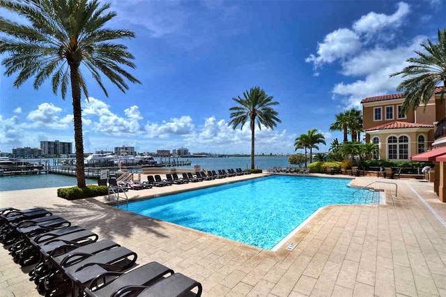 view of pool featuring a water view and a patio area