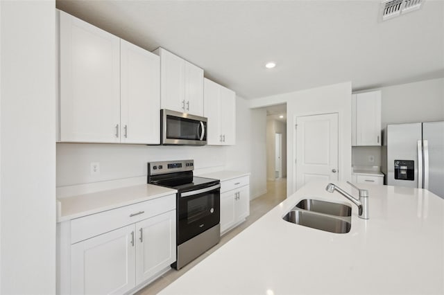 kitchen featuring stainless steel appliances, white cabinets, and sink