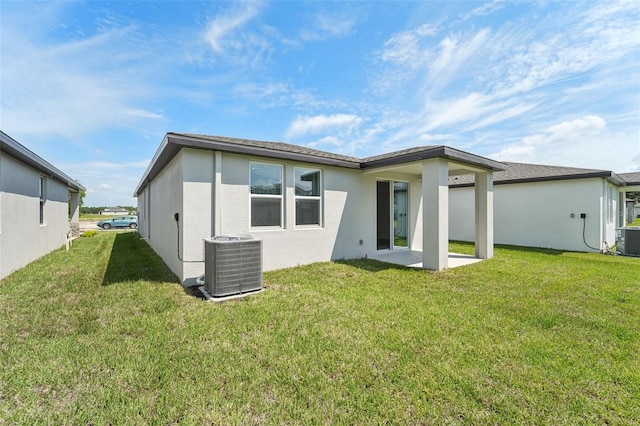 rear view of house featuring a yard, central air condition unit, and a patio