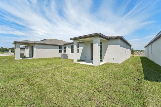 back of house featuring a lawn, central AC, and a patio