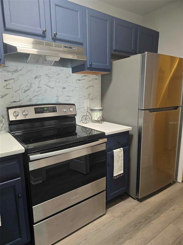 kitchen featuring blue cabinetry, decorative backsplash, light wood-type flooring, and appliances with stainless steel finishes