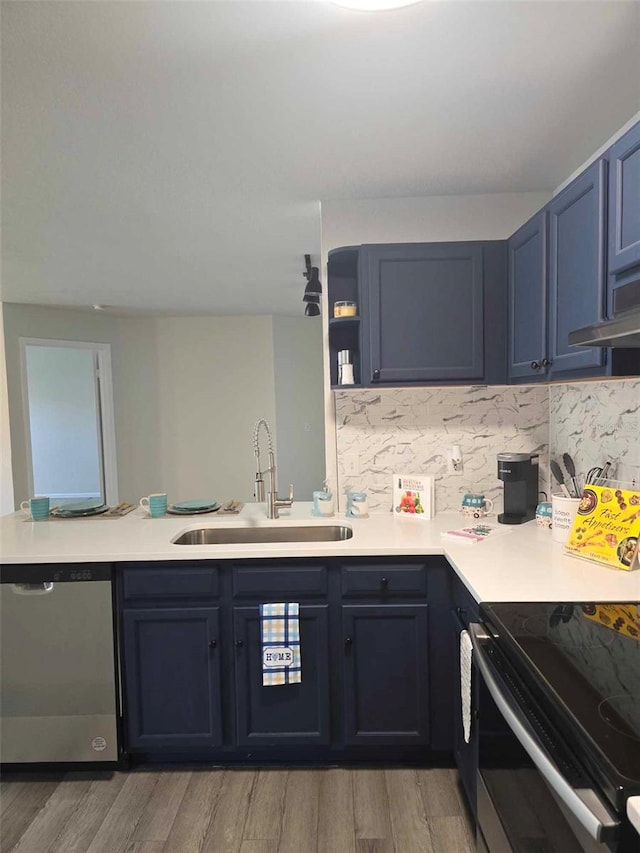 kitchen featuring sink, stainless steel appliances, hardwood / wood-style flooring, and backsplash