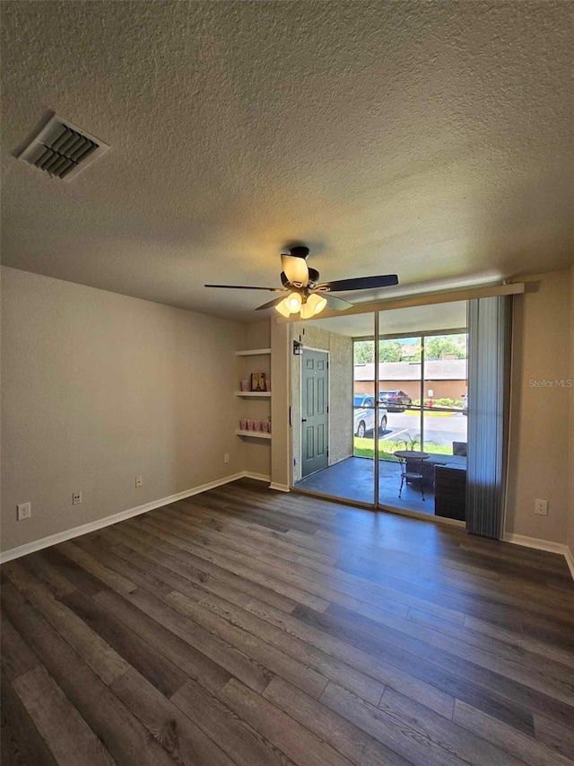 unfurnished room with a textured ceiling, ceiling fan, and dark hardwood / wood-style flooring