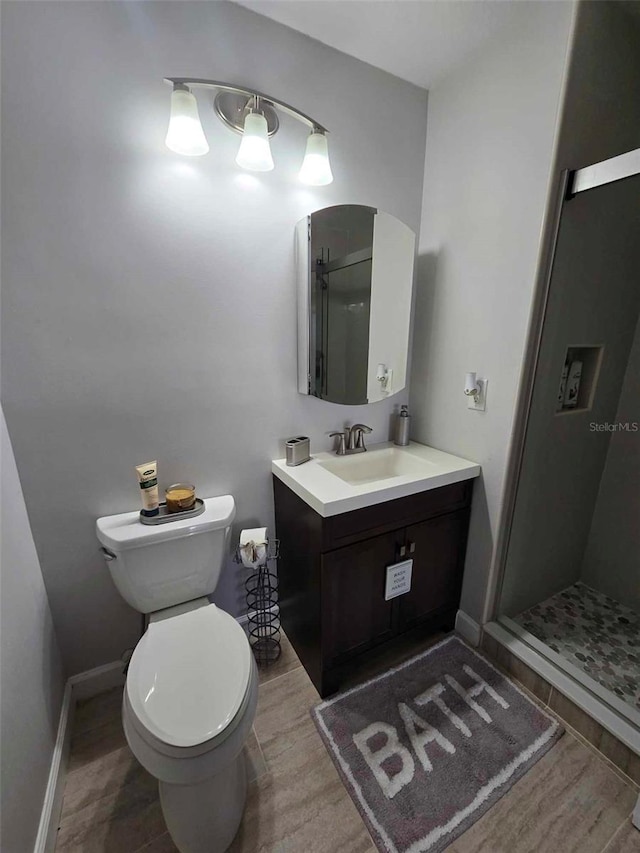 bathroom featuring toilet, a shower with door, hardwood / wood-style flooring, and vanity