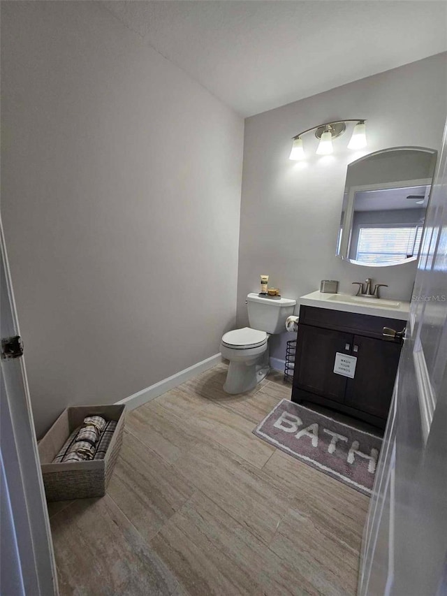 bathroom with hardwood / wood-style flooring, toilet, and vanity