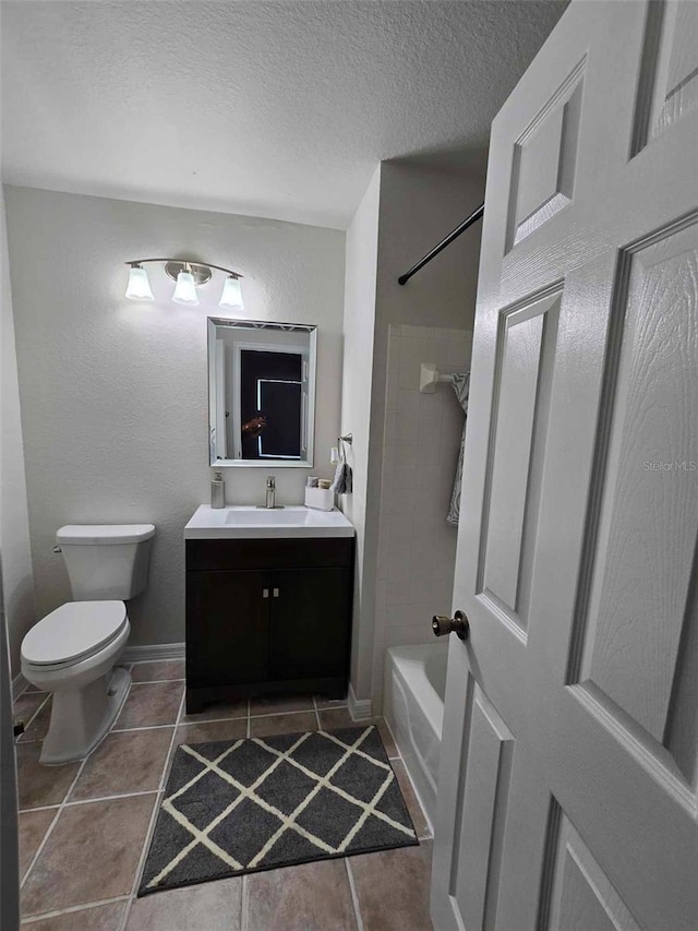 full bathroom with toilet, a textured ceiling, tile patterned flooring, vanity, and tiled shower / bath