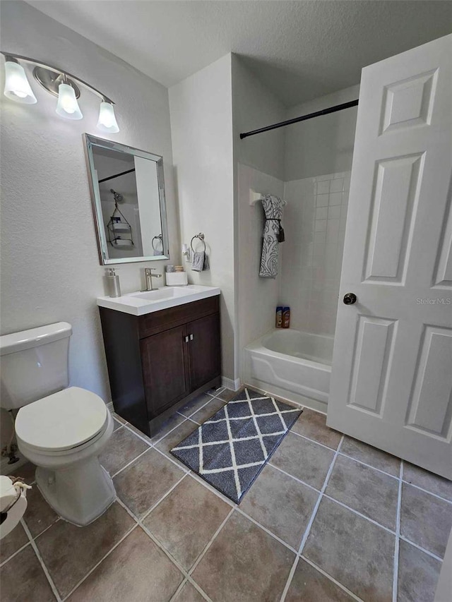 full bathroom featuring tile patterned floors, tiled shower / bath combo, toilet, a textured ceiling, and vanity