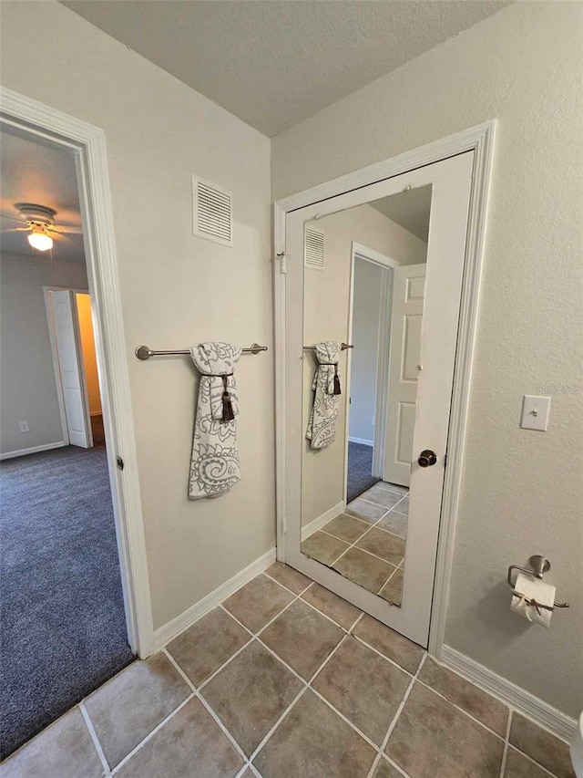 bathroom with ceiling fan and tile patterned floors