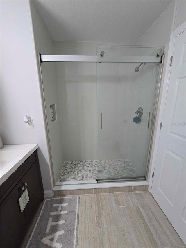 bathroom featuring an enclosed shower and vanity