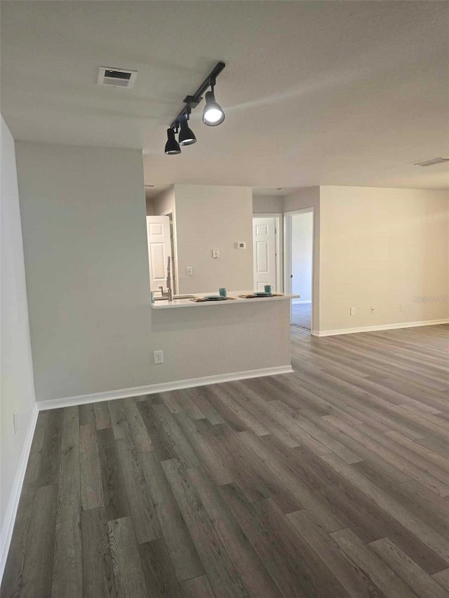 unfurnished room with dark hardwood / wood-style flooring and track lighting