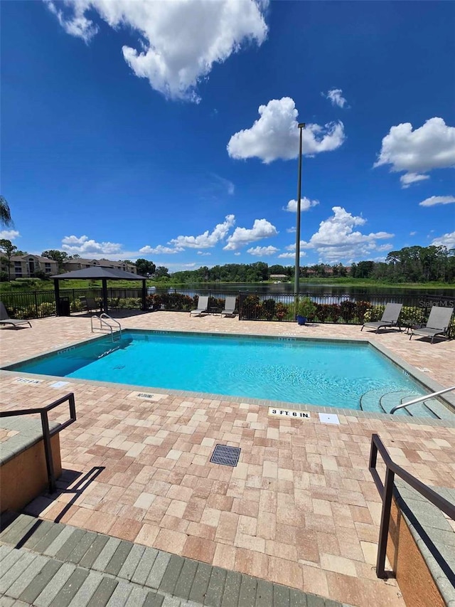 view of pool with a gazebo, a water view, and a patio