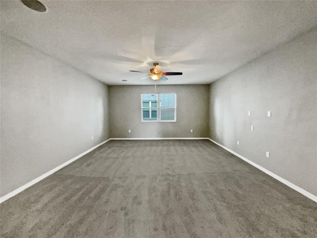 empty room with ceiling fan, dark carpet, and a textured ceiling